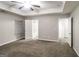 Large bedroom with tray ceiling, plush carpet, and access to en-suite bathroom and closet spaces at 323 Lauren Dr, Fairburn, GA 30213