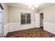 Elegant dining room features wood-look floors, wainscoting and a stylish chandelier at 323 Lauren Dr, Fairburn, GA 30213