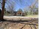 View of home's front exterior, including porch with gravel parking in front of the home at 927 Dean Patrick Rd, Locust Grove, GA 30248