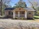 Charming single-story home with a gravel driveway and a cozy front porch at 927 Dean Patrick Rd, Locust Grove, GA 30248
