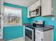 Kitchen featuring stainless steel oven, microwave, white cabinets, and a window overlooking the backyard at 927 Dean Patrick Rd, Locust Grove, GA 30248
