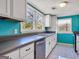 Bright kitchen featuring white cabinets, stainless steel dishwasher, and a large window over the sink at 927 Dean Patrick Rd, Locust Grove, GA 30248