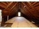 Spacious attic with exposed wooden beams and a window, offering potential for storage or conversion at 76 College St, Mcdonough, GA 30253