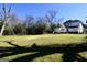 A large open backyard, featuring well-maintained grass, mature trees, and the home's exterior at 76 College St, Mcdonough, GA 30253