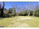Expansive backyard featuring lush green grass and mature trees, offering a serene outdoor space at 76 College St, Mcdonough, GA 30253