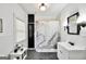Bright bathroom with a white vanity, black faucet, bathtub with shower, and light fixture at 76 College St, Mcdonough, GA 30253