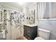 Well-lit bathroom with a dark vanity, a patterned shower curtain, and white fixtures at 76 College St, Mcdonough, GA 30253