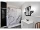 Bright bathroom featuring a shower with marble-patterned curtain, vanity, and decorative lighting fixtures at 76 College St, Mcdonough, GA 30253