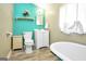 Charming bathroom featuring vintage-style tub and bright turquoise accent wall at 76 College St, Mcdonough, GA 30253