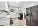 Cozy kitchen with white cabinetry, dark appliances, and wood-look floors leading to office at 76 College St, Mcdonough, GA 30253