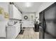 Galley kitchen with white cabinets, laminate floor, black appliances and white countertops at 76 College St, Mcdonough, GA 30253