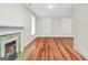 Living room featuring hardwood floors, a decorative fireplace, and two large windows at 76 College St, Mcdonough, GA 30253