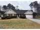 Charming single story brick home featuring an attached garage and meticulously landscaped front yard at 215 Buck Run, Loganville, GA 30052