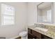 Bathroom featuring granite countertop, wood cabinet and ample lighting with tiled shower in background at 7754 Hansel Ln, Lithonia, GA 30058