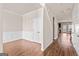 Spacious living room featuring wood floors, wainscoting, and access to the kitchen and staircase at 7754 Hansel Ln, Lithonia, GA 30058