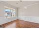 Bright living room featuring wood floors, large window and decorative wainscoting at 7754 Hansel Ln, Lithonia, GA 30058