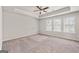 Spacious primary bedroom boasts a tray ceiling and three large windows for ample light at 7754 Hansel Ln, Lithonia, GA 30058