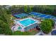An aerial view of the community swimming pool, tennis courts and surrounding green landscape at 1654 Summersweet Ln, Dacula, GA 30019