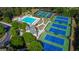 Aerial view of tennis courts and a beautiful pool with a slide and a covered area at 1654 Summersweet Ln, Dacula, GA 30019