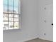 Carpeted room with white walls features a single window and a door at 1654 Summersweet Ln, Dacula, GA 30019