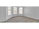 Bright bedroom has three windows, neutral carpet, white walls, and white trim at 1654 Summersweet Ln, Dacula, GA 30019