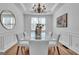 Elegant dining room with a modern chandelier and a glass table with seating for eight at 1654 Summersweet Ln, Dacula, GA 30019