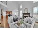 Open living room with fireplace, hardwood floors, and view into the modern kitchen at 1654 Summersweet Ln, Dacula, GA 30019