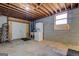 Unfinished basement with concrete floors, cinder block walls, exposed ceiling, washer-dryer, and ladder at 825 Sugar Creek Se Way, Conyers, GA 30094