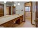 Bathroom vanity with a long marble countertop, sink, wood cabinets, and two hanging lights at 825 Sugar Creek Se Way, Conyers, GA 30094