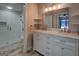 Bathroom with white vanity with double sinks, walk-in closet, and glass shower at 825 Sugar Creek Se Way, Conyers, GA 30094