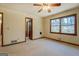 A bright bedroom with neutral walls, carpet, a ceiling fan, and a window to view nature at 825 Sugar Creek Se Way, Conyers, GA 30094