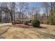 Landscaped front yard with mature trees and circular driveway enhance this home's curb appeal at 825 Sugar Creek Se Way, Conyers, GA 30094