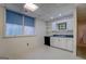 Basement kitchen featuring white cabinetry, dark countertop and sink, and a window allowing natural light at 825 Sugar Creek Se Way, Conyers, GA 30094