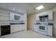 Basement kitchen with white cabinets, laminate flooring, and stainless steel appliances at 825 Sugar Creek Se Way, Conyers, GA 30094