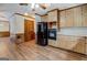 Kitchen featuring wood cabinets, black appliances, and wood-look floors at 825 Sugar Creek Se Way, Conyers, GA 30094