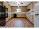 A traditional kitchen with wood cabinets, black appliances, and wood-look floors at 825 Sugar Creek Se Way, Conyers, GA 30094