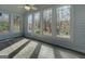 Bright sunroom with gray flooring, shiplap walls, and large windows overlooking the backyard at 825 Sugar Creek Se Way, Conyers, GA 30094