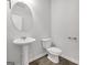 Powder room featuring a pedestal sink, oval mirror, and modern fixtures at 789 Galveston Way, Mcdonough, GA 30253