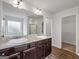 Primary bathroom showcasing double sinks, wood cabinets, and modern lighting at 789 Galveston Way, Mcdonough, GA 30253