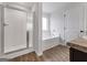 Modern bathroom showcasing a glass enclosed shower, soaking tub, and wood look flooring at 789 Galveston Way, Mcdonough, GA 30253