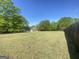 A sunny backyard with a well maintained lawn and a fence on the right side at 848 Still Rd, Lawrenceville, GA 30045