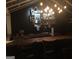 Indoor bar area with a sink, shelving displaying liquor bottles, wooden countertop, lighting, and barstools for seating at 848 Still Rd, Lawrenceville, GA 30045