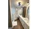 Modern bathroom with double vanity, wood floors, and glass shower at 848 Still Rd, Lawrenceville, GA 30045