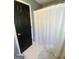 Bathroom with a black door, white tiled floors, and a white shower curtain at 848 Still Rd, Lawrenceville, GA 30045