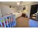 Well-lit bedroom with a crib, queen bed, ceiling fan, and a classic decorative wall clock at 848 Still Rd, Lawrenceville, GA 30045