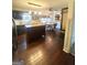 Open-concept kitchen with dark cabinets, granite counters, a central island, hardwood flooring, and adjacent dining area at 848 Still Rd, Lawrenceville, GA 30045