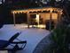 Outdoor patio featuring stone trim, chair, covered area with bistro lights, and a built-in bar area with a counter and seating at 848 Still Rd, Lawrenceville, GA 30045