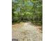 Gravel driveway leads to a property with parked RVs and trailers surrounded by trees at 848 Still Rd, Lawrenceville, GA 30045