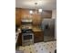Kitchen with stainless steel appliances, wood cabinets, and vintage tile floors at 5865 Vernier Dr, Atlanta, GA 30349