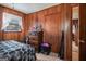 Bedroom featuring wood-paneled walls, window, dresser with mirror, and door to another room at 143 Teamon Rd, Hampton, GA 30228